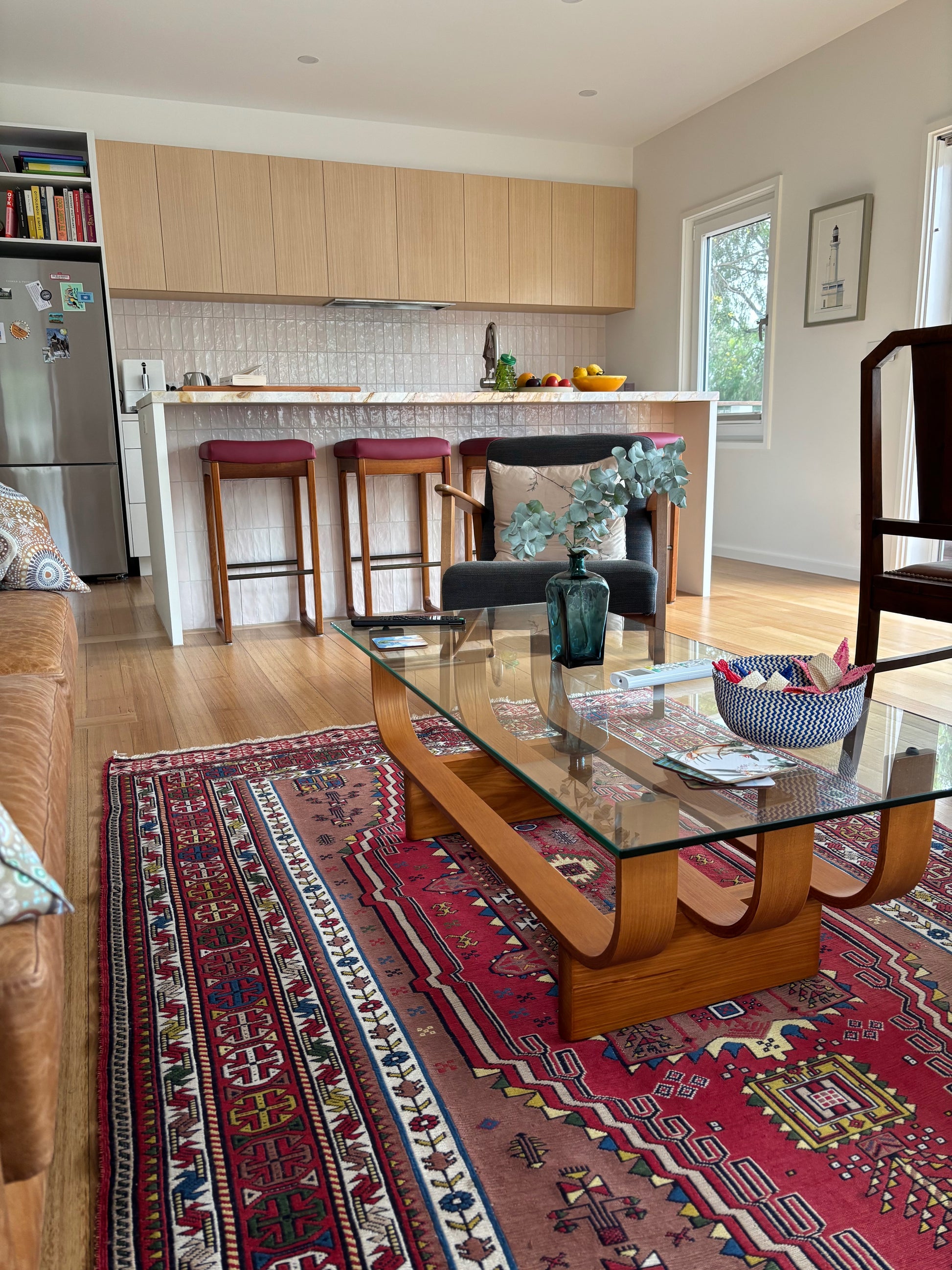 TH Brown Aquarius Coffee Table with timber frame and glass top, styled on a colorful Persian rug in a warm, eclectic Australian home.