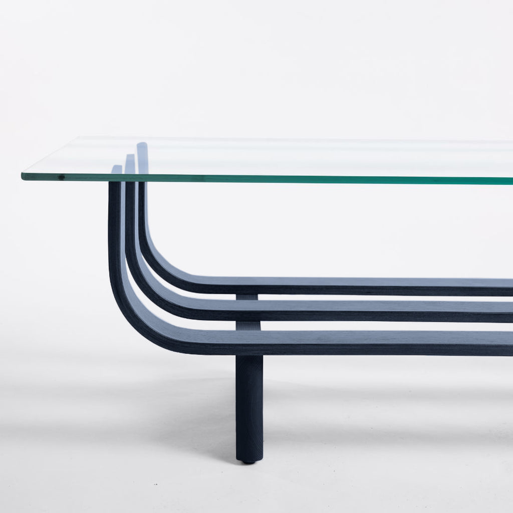 TH Brown Aquarius Coffee Table in Matt Black Ash with clear glass, blending natural timber warmth and sculptural form for timeless modern Australian living.