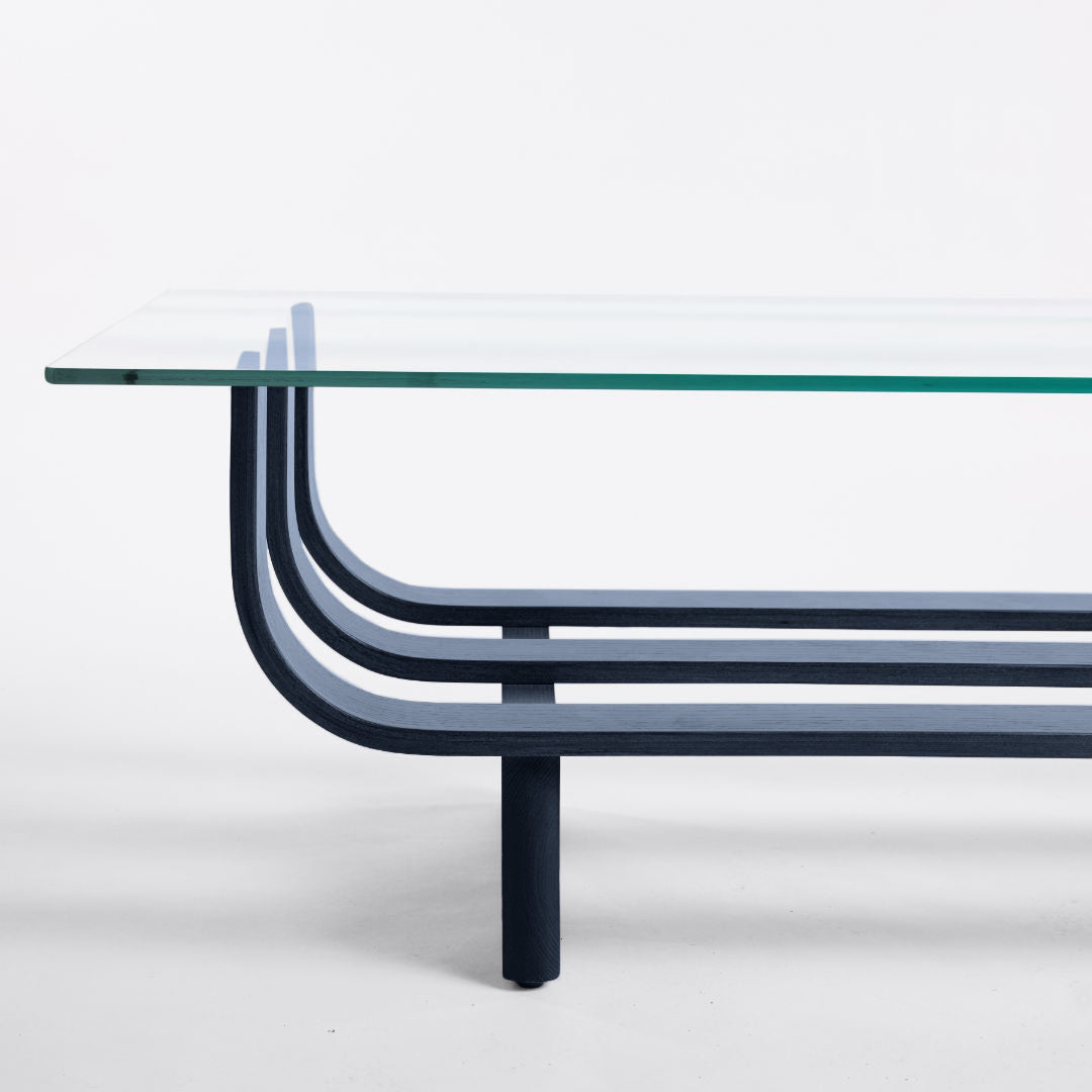 TH Brown Aquarius Coffee Table in Matt Black Ash with clear glass, blending natural timber warmth and sculptural form for timeless modern Australian living.