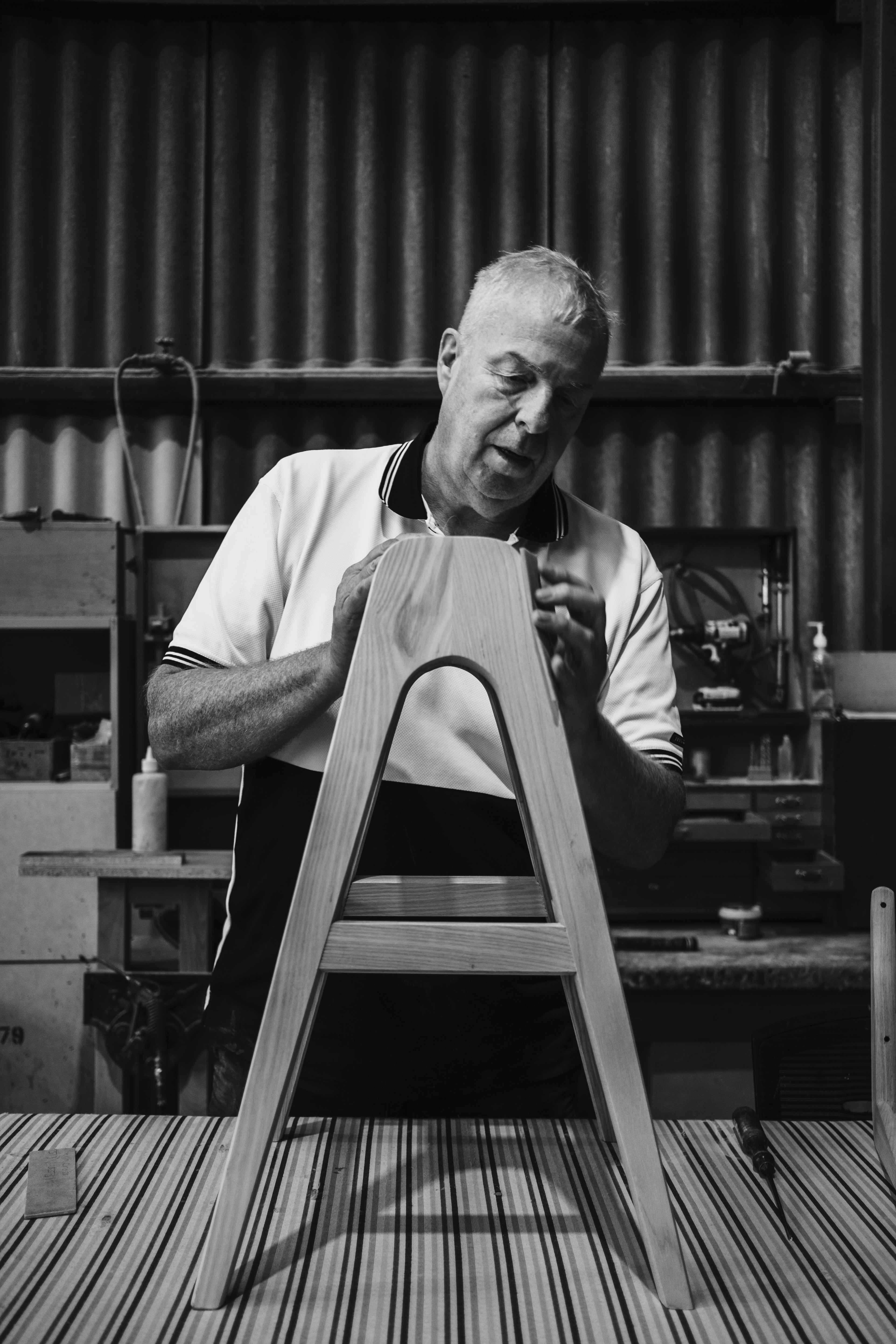 TH Brown craftsman hand-finishing a timber Danish Bar Stool in the Adelaide workshop, showcasing Australian-made furniture craftsmanship