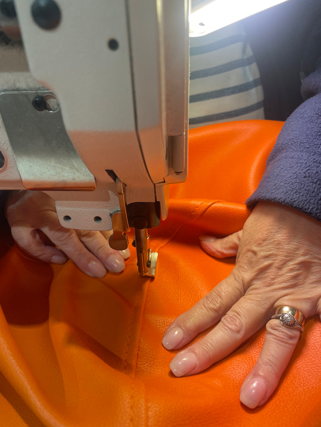 TH Brown Rondo Pouffe being sewn by hand, highlighting the craftsmanship and care behind Australian-made furniture.