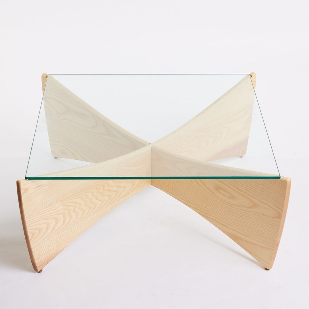 TH Brown Venus Coffee Table in Clear Ash with clear glass top, blending warm natural timber and sculptural form for modern Australian living.