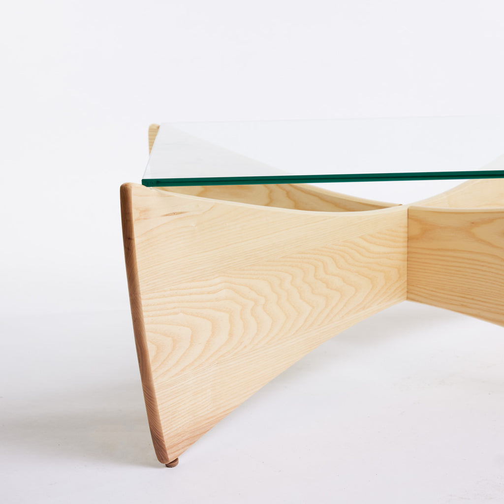 TH Brown Venus Coffee Table in Clear Ash with clear glass top, blending warm natural timber and sculptural form for modern Australian living.