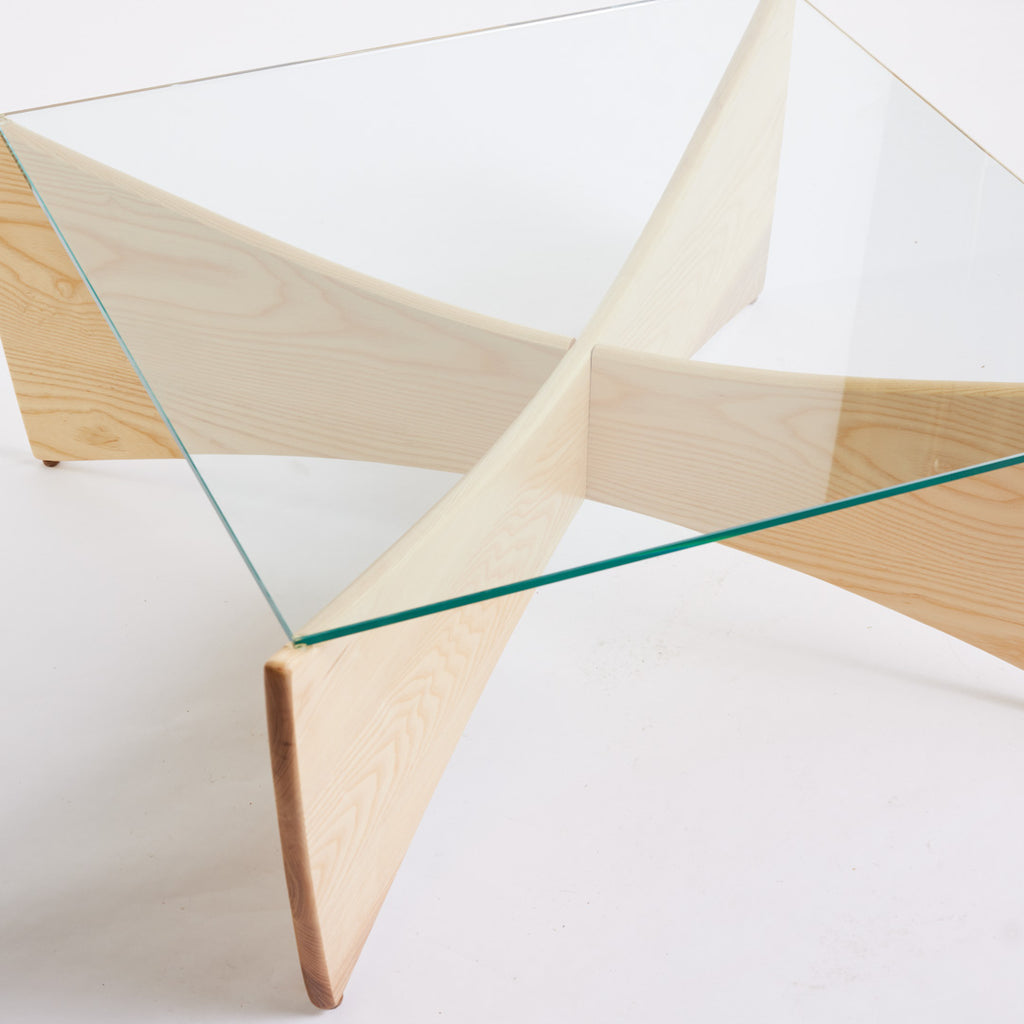 TH Brown Venus Coffee Table in Clear Ash with clear glass top, blending warm natural timber and sculptural form for modern Australian living.