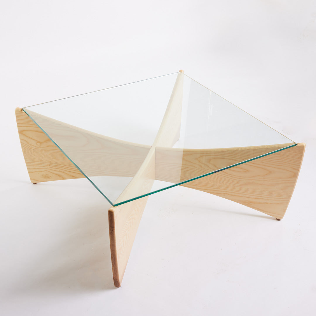 TH Brown Venus Coffee Table in Clear Ash with clear glass top, blending warm natural timber and sculptural form for modern Australian living.