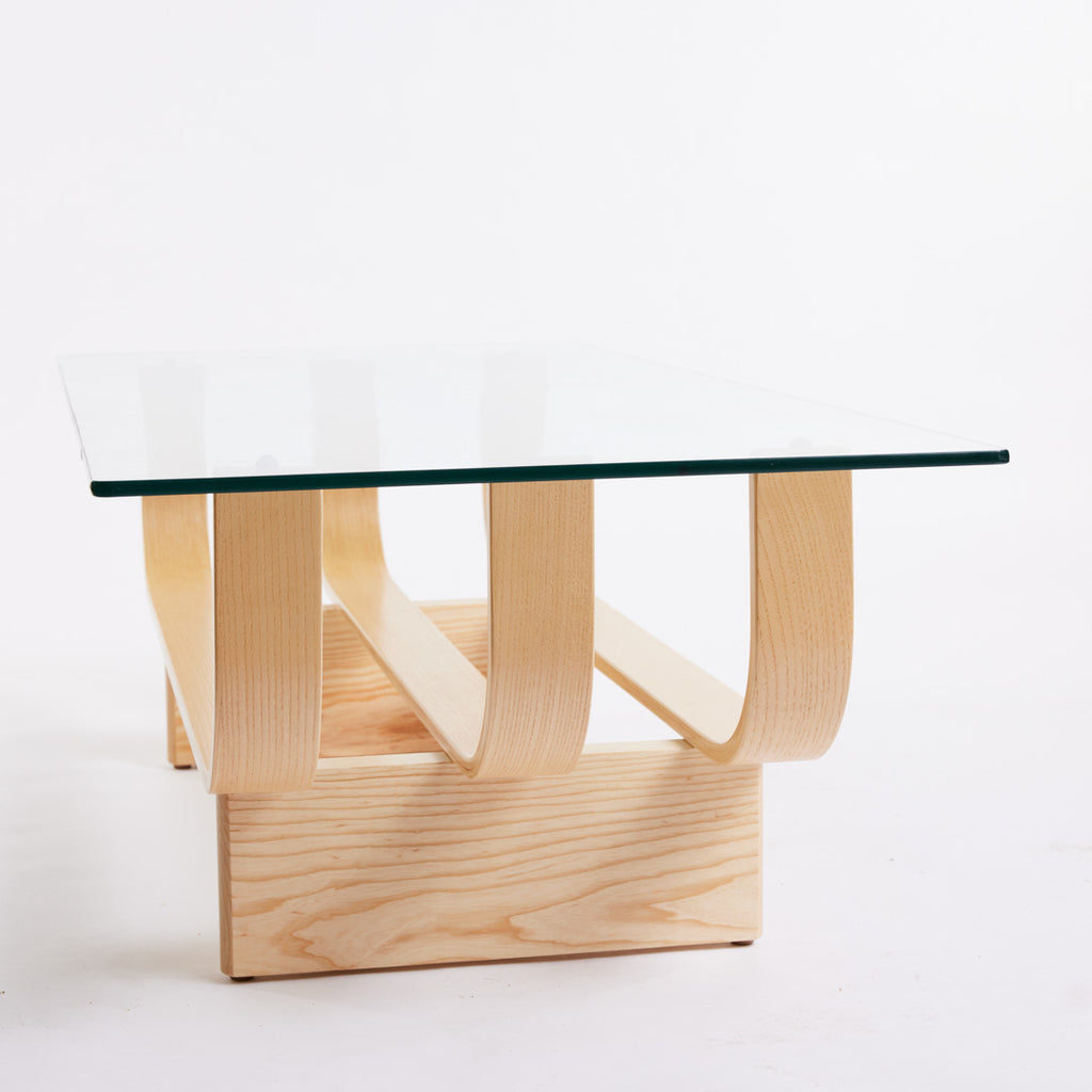 TH Brown Aquarius Coffee Table in Clear Ash with clear glass, blending natural timber warmth and sculptural form for timeless modern Australian living.