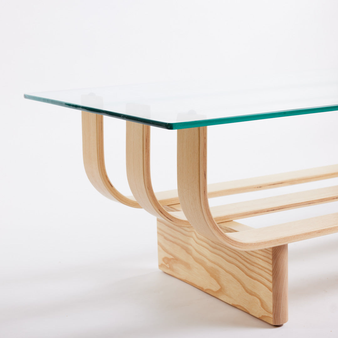 TH Brown Aquarius Coffee Table in Clear Ash with clear glass, blending natural timber warmth and sculptural form for timeless modern Australian living.