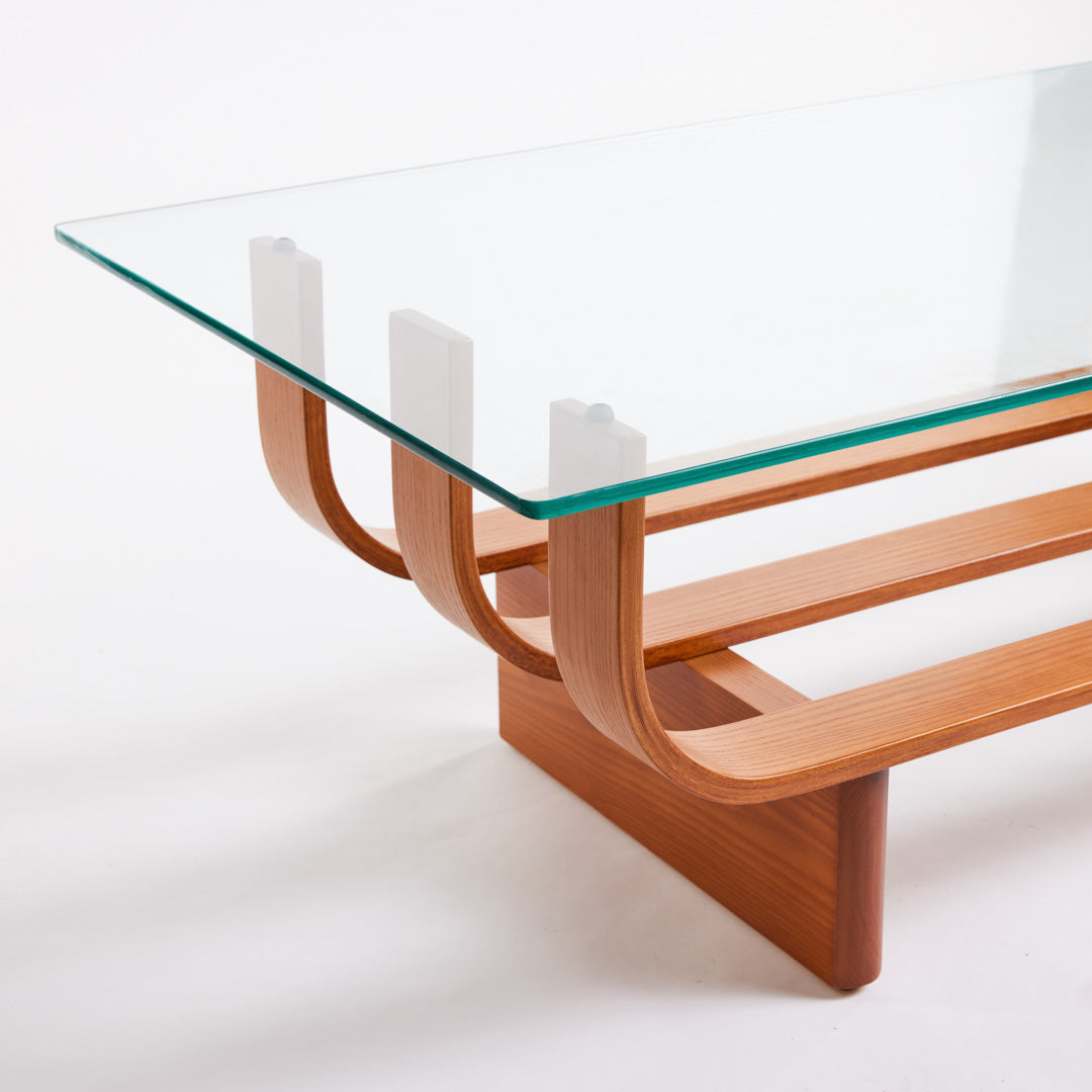 TH Brown Aquarius Coffee Table in Teak Ash with clear glass, blending natural timber warmth and sculptural form for timeless modern Australian living.