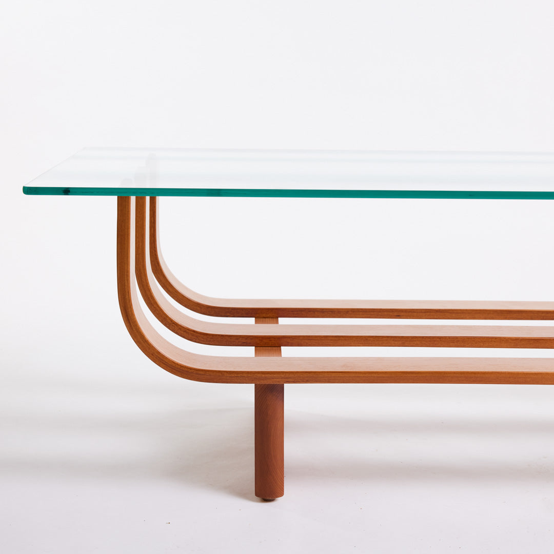 TH Brown Aquarius Coffee Table in Teak Ash with clear glass, blending natural timber warmth and sculptural form for timeless modern Australian living.