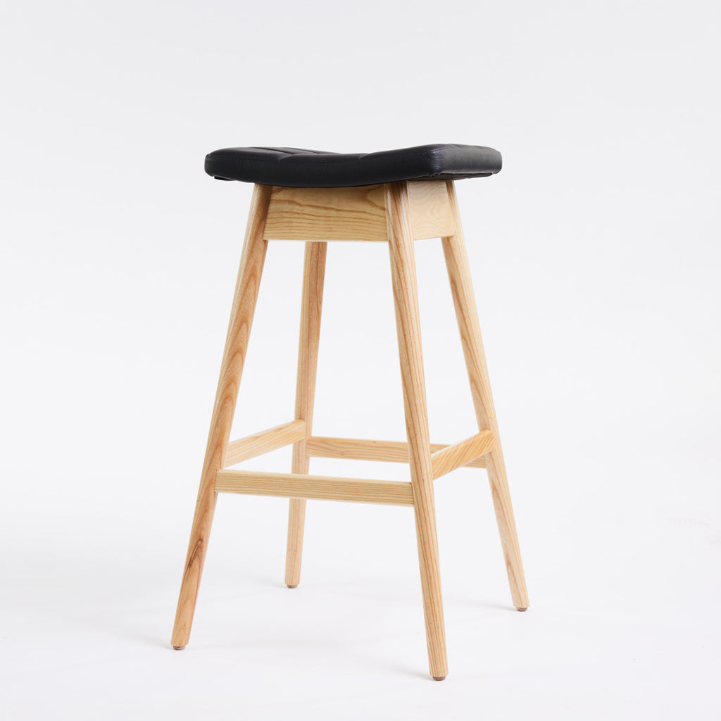TH Brown Martelle Bar Stool in Black with Clear Ash frame, blending bold upholstery and natural timber for refined modern Australian living.