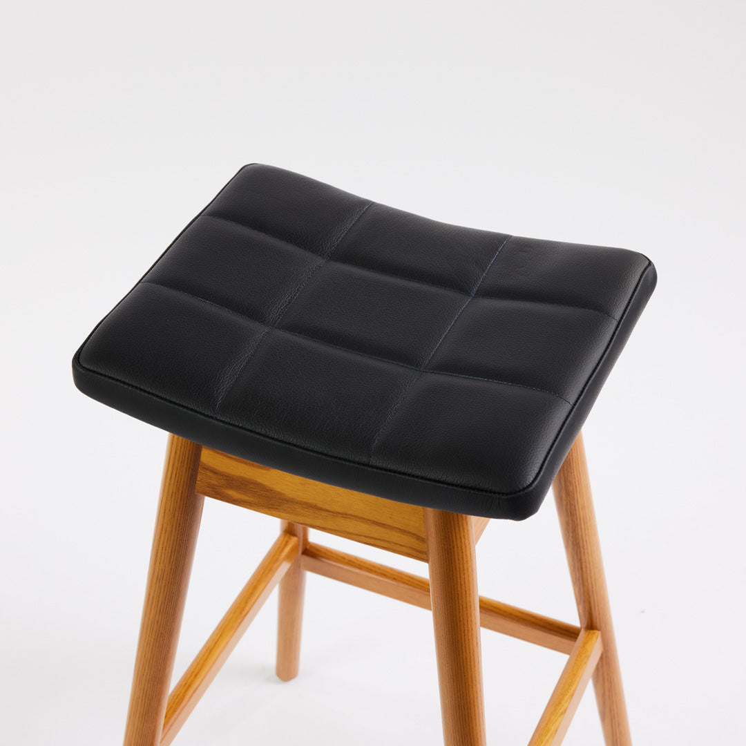 TH Brown Martelle Bar Stool in Black with Light Ash frame, blending bold upholstery and pale timber for striking modern Australian living.