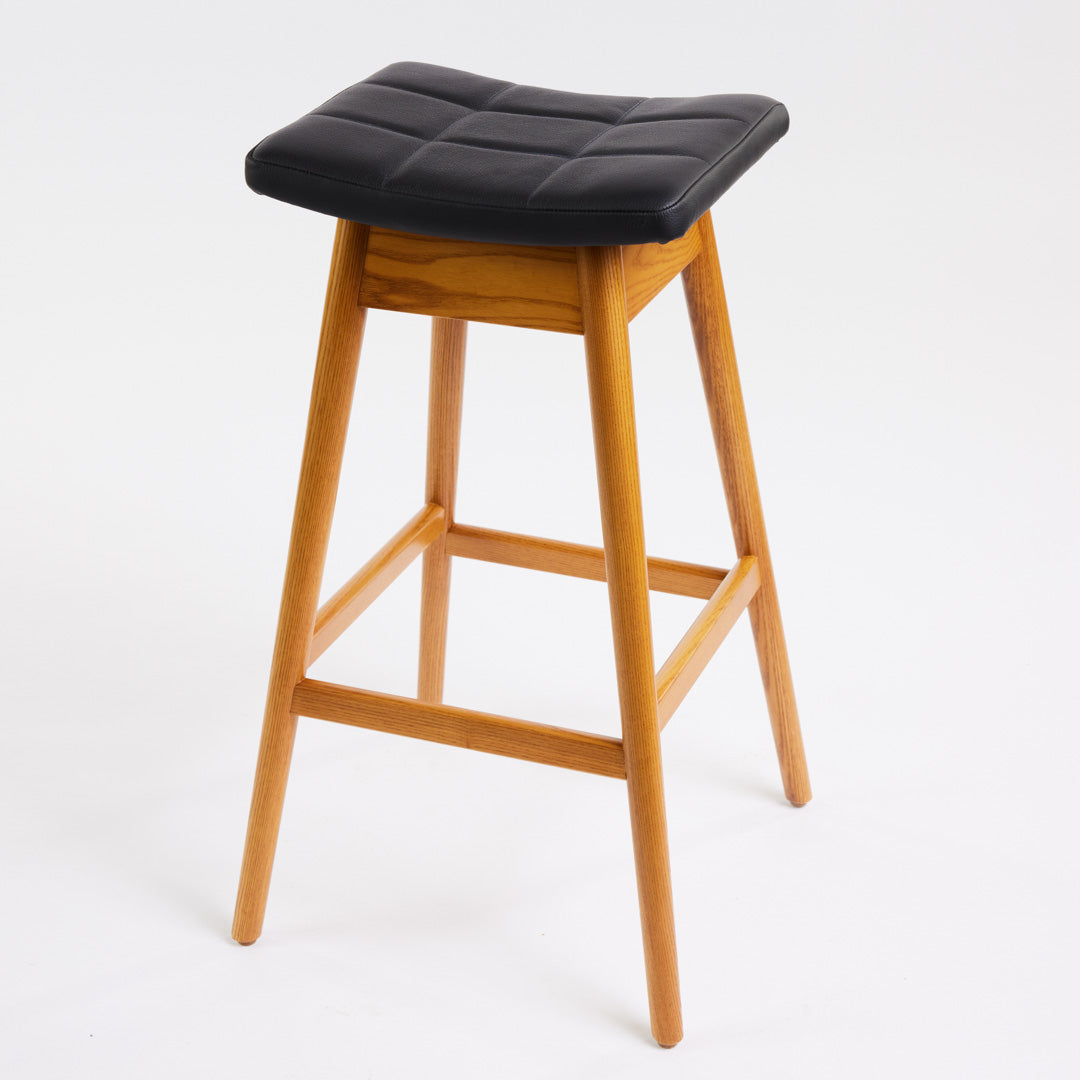 TH Brown Martelle Bar Stool in Black with Light Ash frame, blending bold upholstery and pale timber for striking modern Australian living.