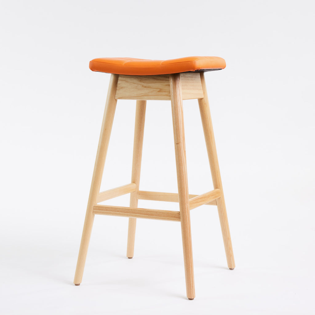 TH Brown Martelle Bar Stool in Calypso Orange with Clear Ash frame, blending vibrant colour and natural timber for playful modern Australian living.