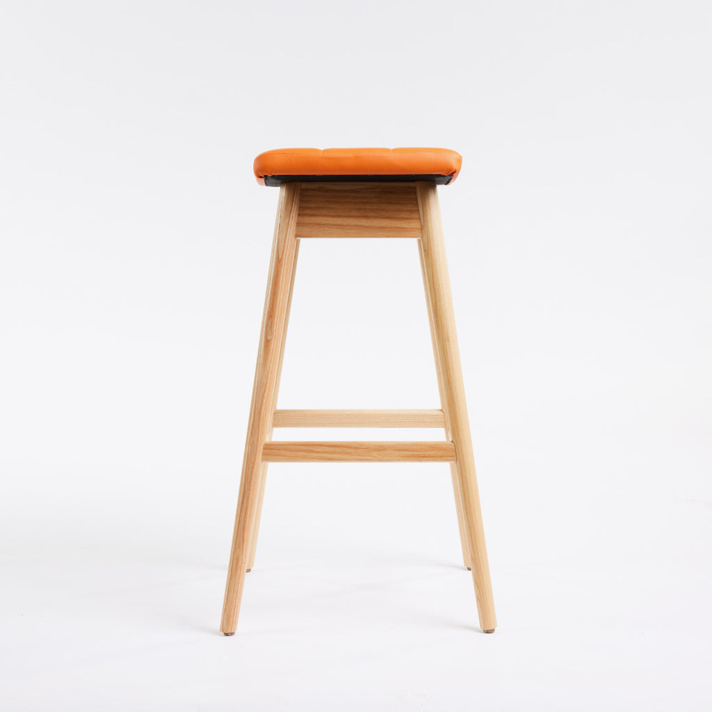 TH Brown Martelle Bar Stool in Calypso Orange with Clear Ash frame, blending vibrant colour and natural timber for playful modern Australian living.