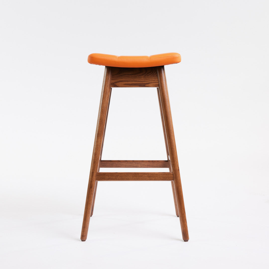 TH Brown Martelle Bar Stool in Calypso Orange with Dark Ash frame, blending vibrant colour and rich timber tones for bold modern Australian living.