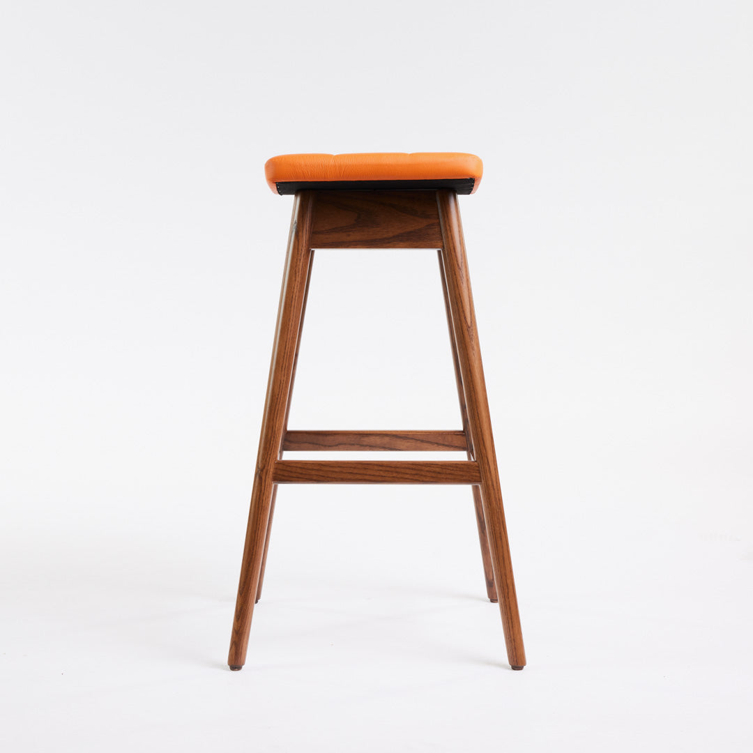 TH Brown Martelle Bar Stool in Calypso Orange with Dark Ash frame, blending vibrant colour and rich timber tones for bold modern Australian living.